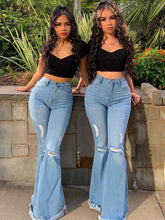 Vaqueros de mezclilla desgastados, deshilachados y con parte inferior acampanada